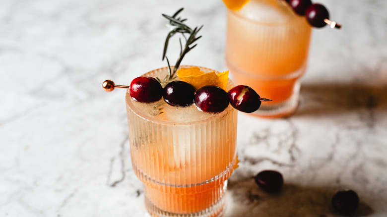 two cocktail glasses with garnishes