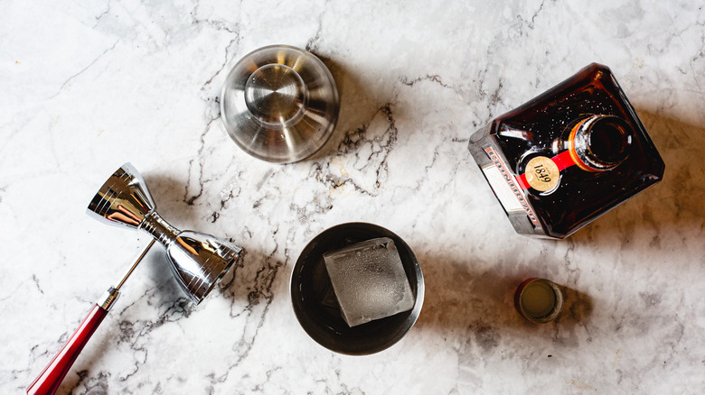 orange liqueur beside shaker with cocktail