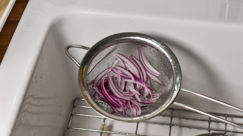 rinsing red onion slices
