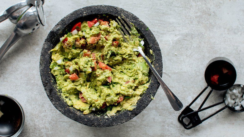 guacamole with tomatoes and fork