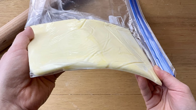 holding butter in plastic bag