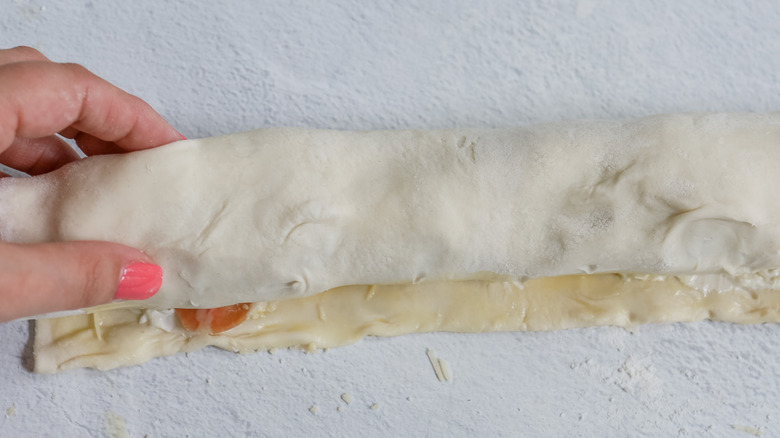 hand rolling stuffed puff pastry