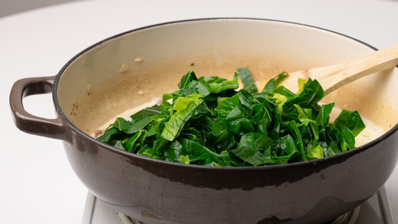 adding greens to a pan