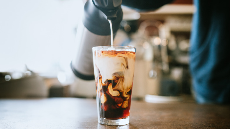 pouring half-and-half in coffee