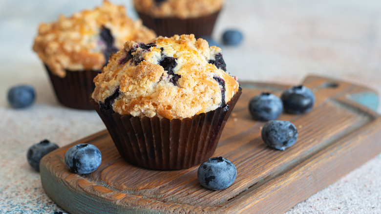 blueberry muffins with blueberries on cutting board