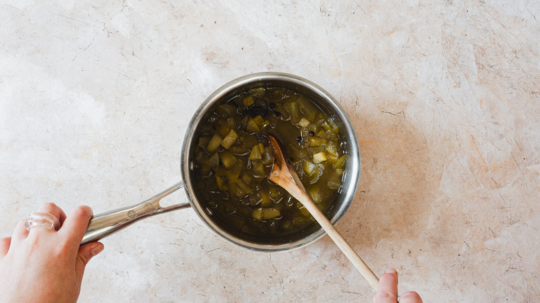 Hand mixing apple sauce in pot