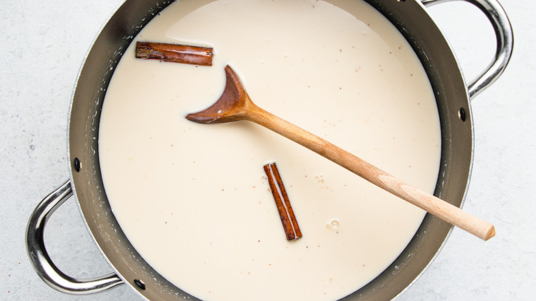 milk and cinnamon sticks in pot