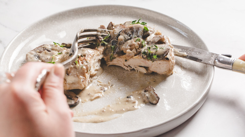 Cutting chicken marsala cutlet in half