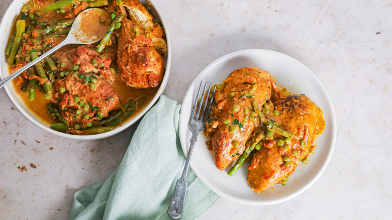 chicken with peas, asparagus and tomato sauce on plate