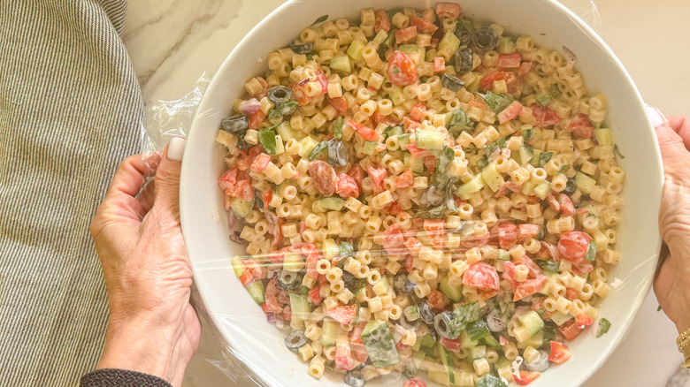 hands covering bowl with wrap