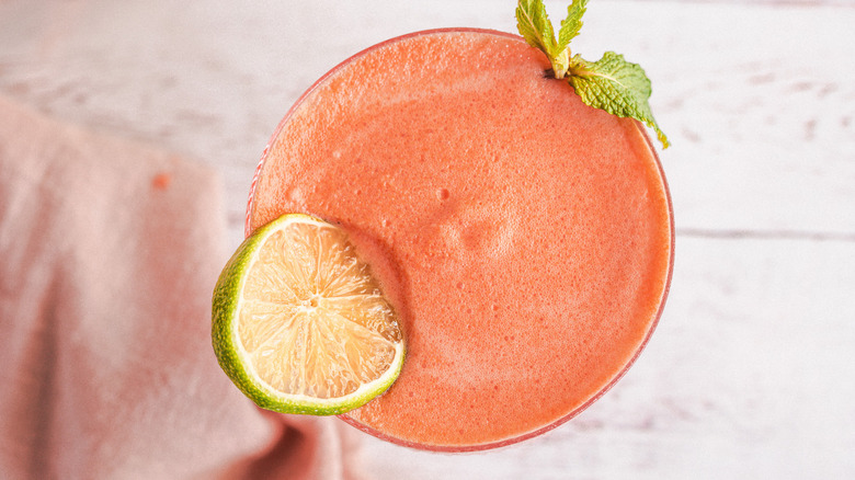 Overhead view of drink with lime slice and mint