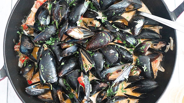 Mussels cooking in a large pan