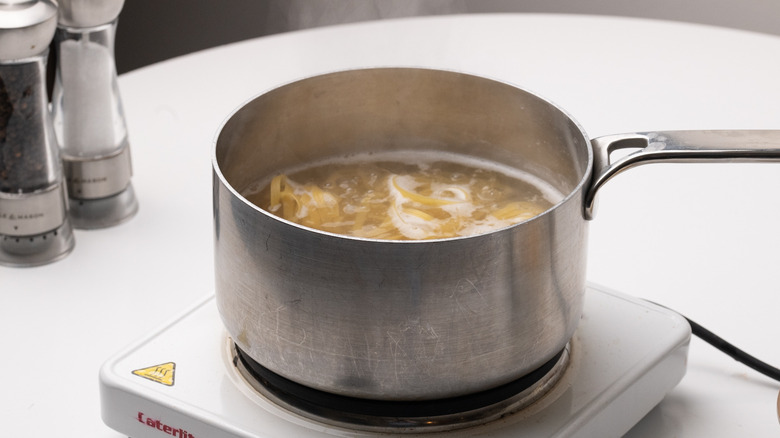 fettuccine cooking in saucepan 