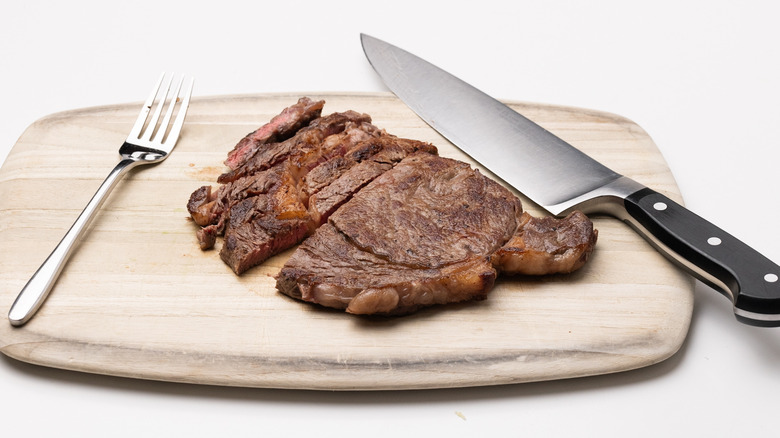 sliced steak on wooden cutting board