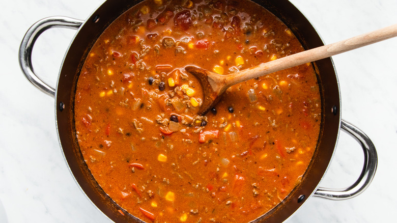 soup in pot with wooden spoon