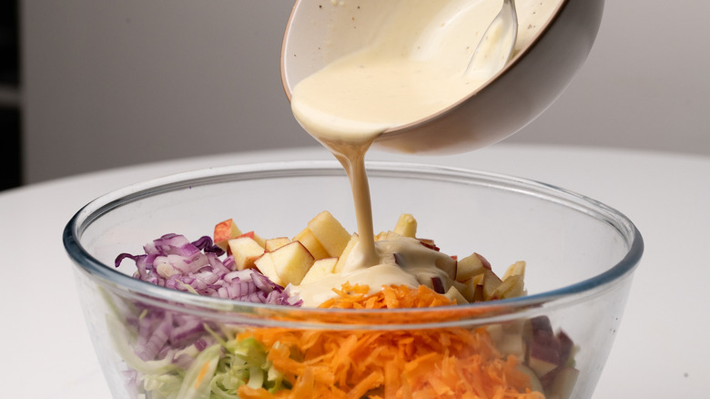 pouring dressing into apple slaw