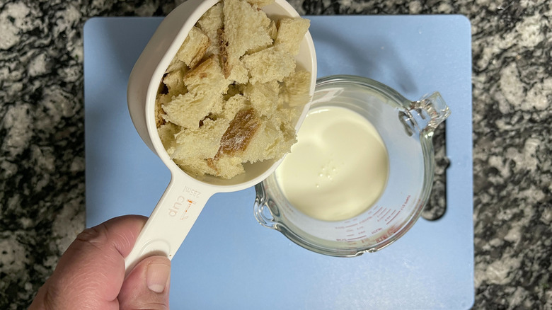 hand putting bread into cream