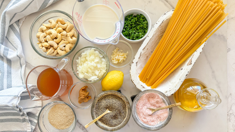 Vegan fettuccine Alfredo ingredients laid out on a marble counter