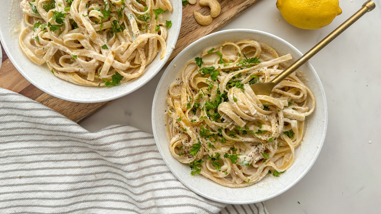 Two bowls of pasta with a lemon and tea towel