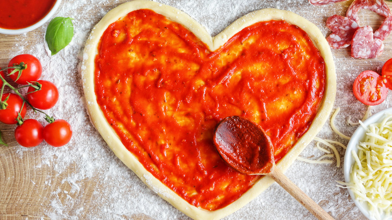 Spoon resting on pizza dough