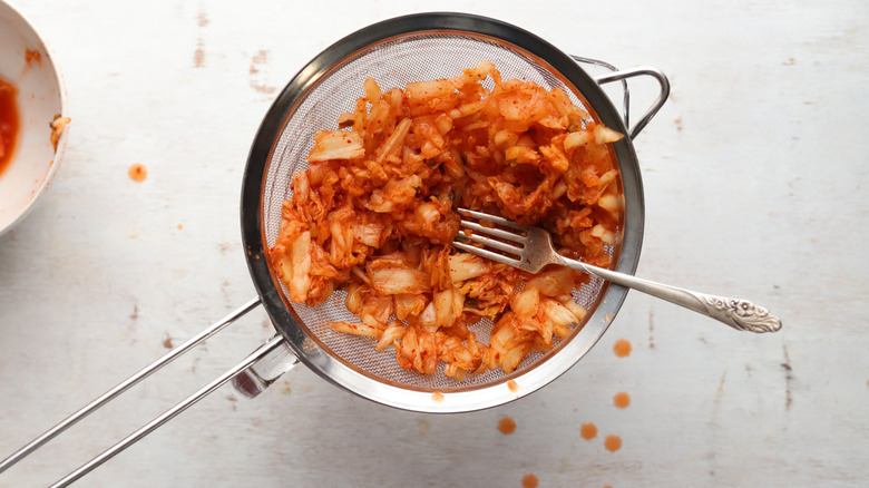 kimchi in metal strainer