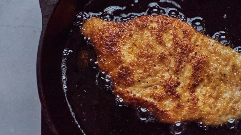 breaded chicken frying in oil