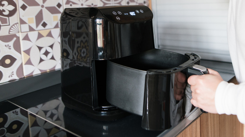 Person making food with an air fryer.