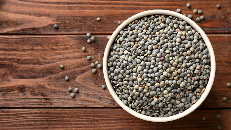 bowl with black lentils on a wood surface