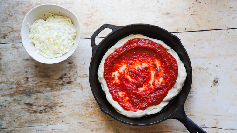 Pizza dough topped with sauce