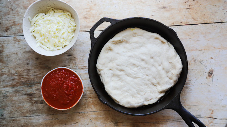 Pizza dough in oiled skillet