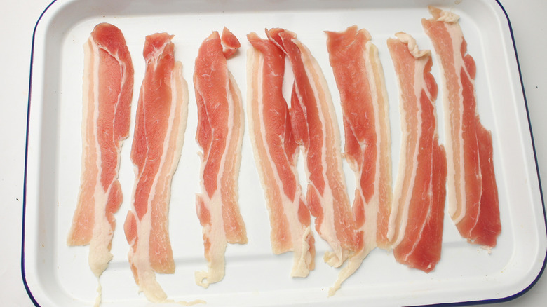 raw bacon on baking sheet