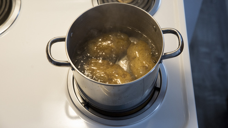 three potatoes in boiling water