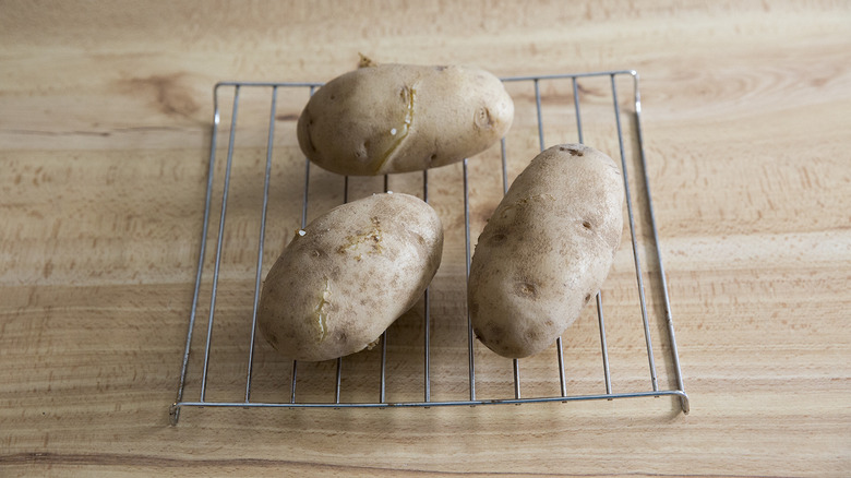 three potatoes on cooling rack