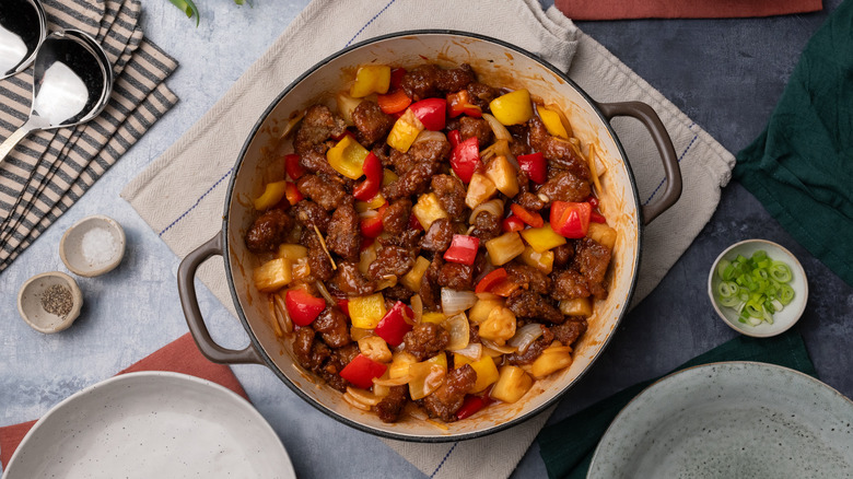 sweet and sour pork with peppers and pineapple in pan