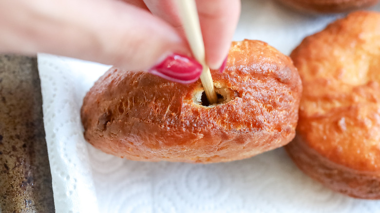 hand poking hole in donut