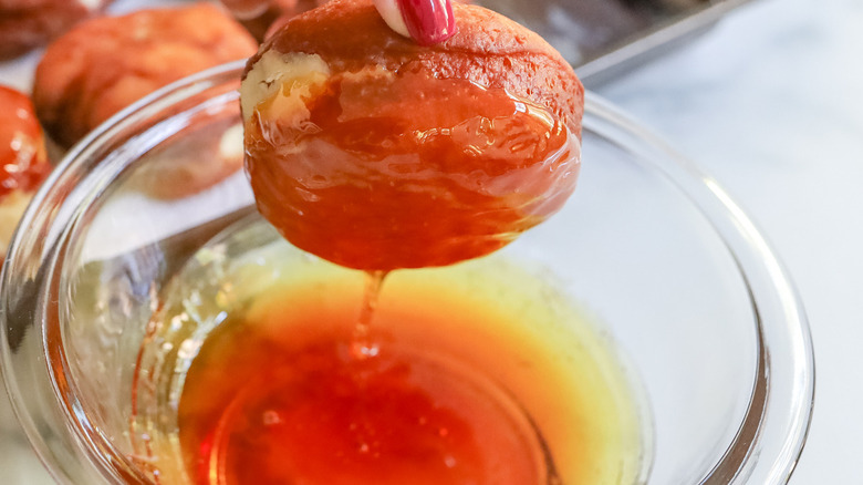 donut being dipped in caramel