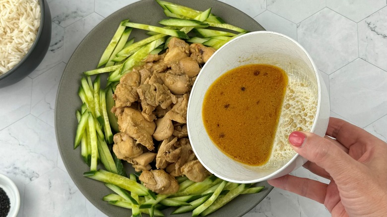 pouring sauce over chicken dish