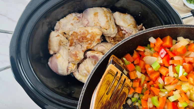 adding vegetables to chicken