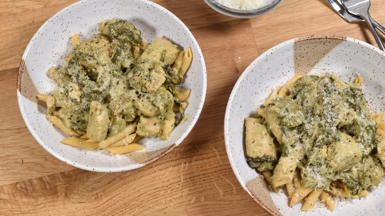 spinach artichoke pasta with chicken in bowls