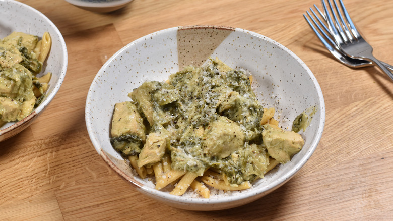 spinach artichoke pasta with chicken in bowl