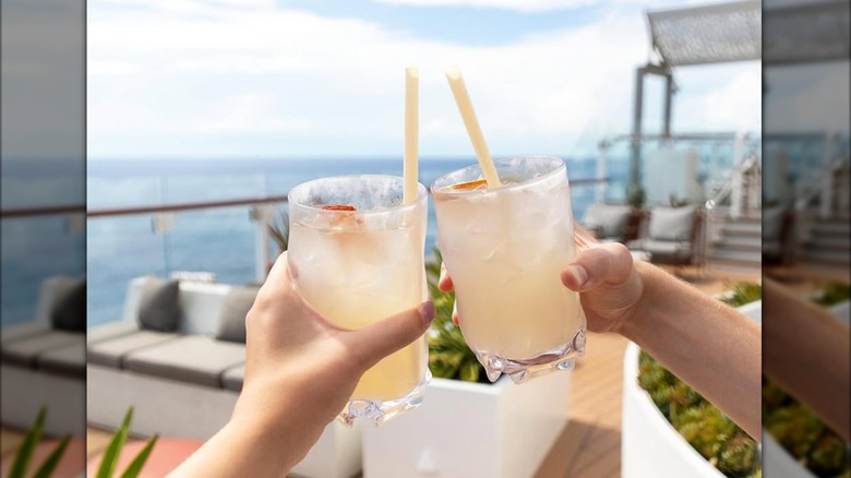 two people holding up cocktails onboard Celebrity Cruise Line