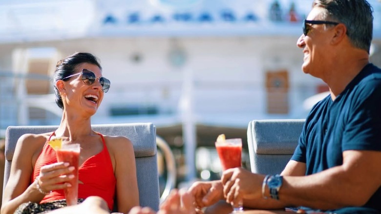 two passengers enjoying a drink by the pool on Azamara cruises
