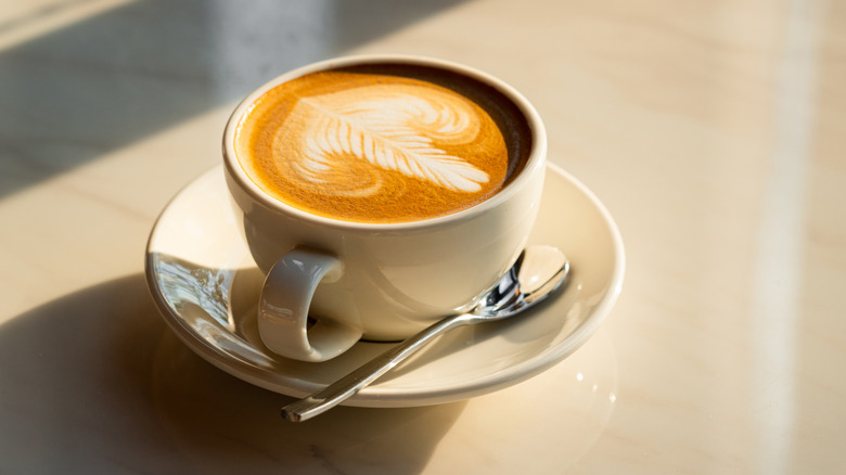 Cup of coffee with spoon resting next to it