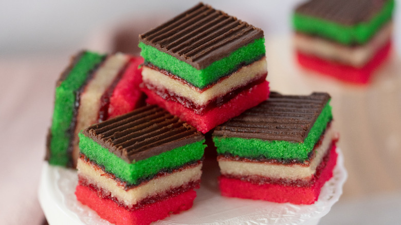 Small pieces of Rainbow cookies stacked on stand