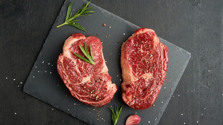 two raw ribeye steaks