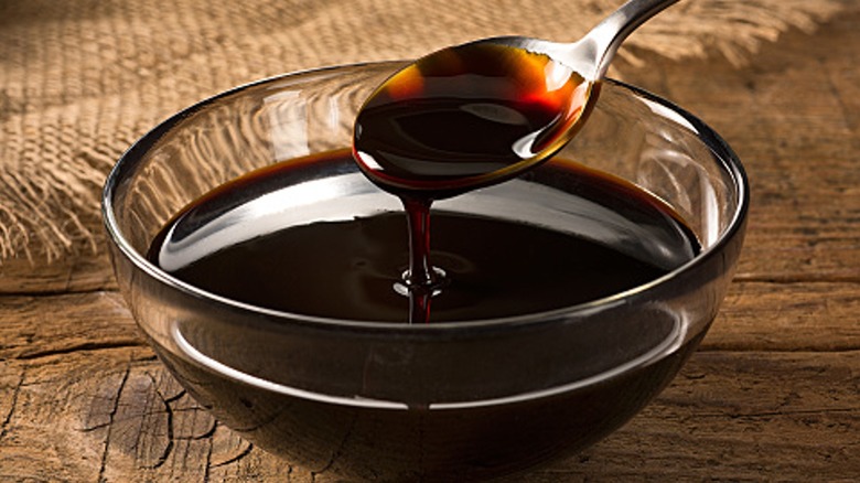 A spoon dipping into a bowl of molasses