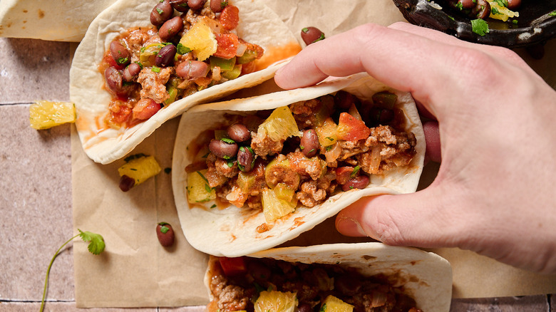 hand holding picadillo taco