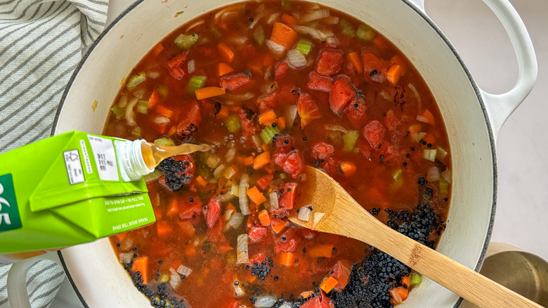 adding broth to soup