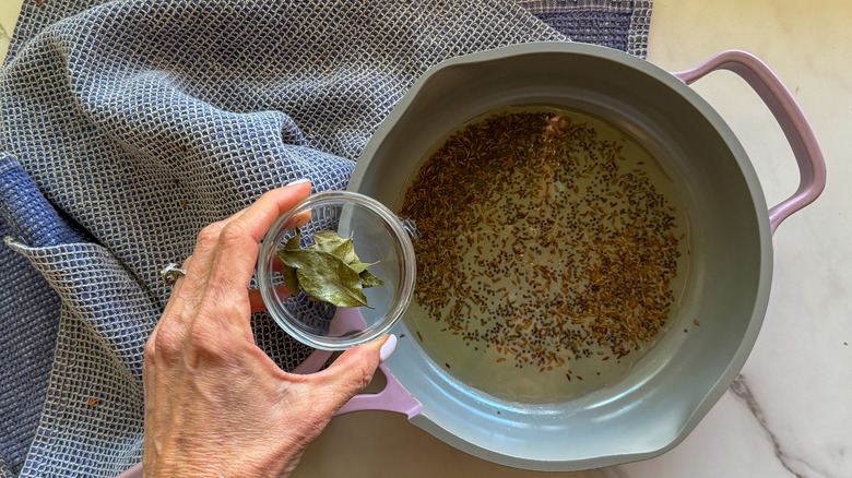 adding curry leaves to pan