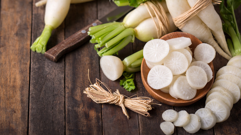 whole and sliced daikon on a wooden table